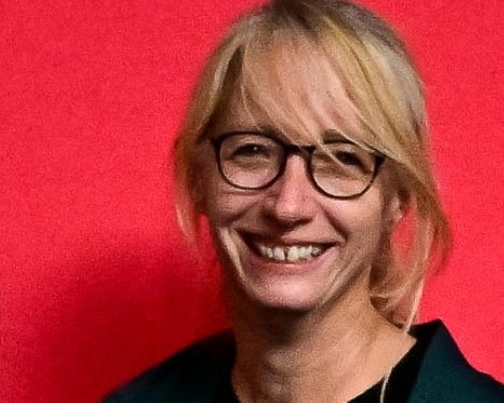 Bild von Iris Sitta: blonde Haare, Brille, ein breites Lächeln